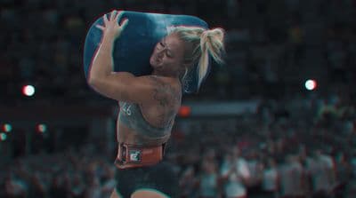 a woman in a wrestling ring holding a blue ball