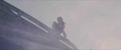 a woman standing on top of a wooden structure