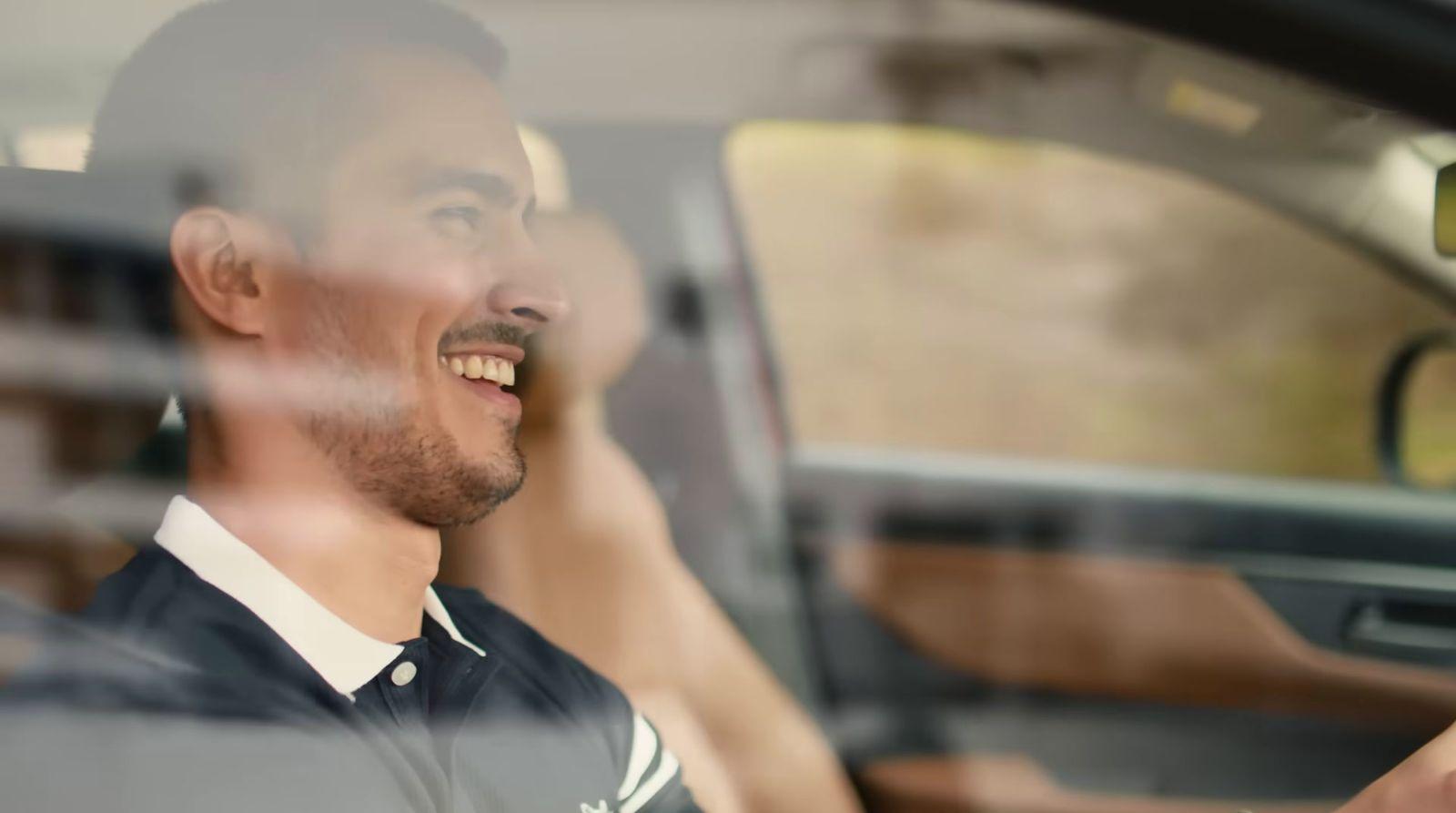 a man sitting in a car and smiling