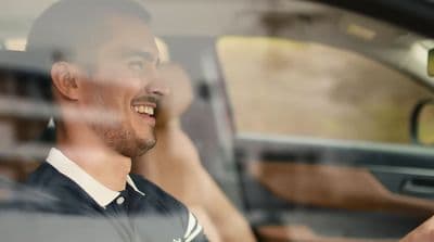 a man sitting in a car and smiling