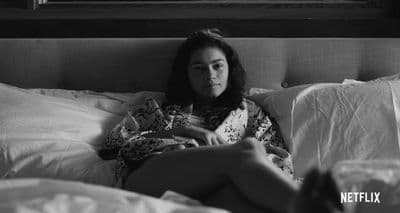 a woman laying in bed with her legs crossed