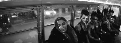 a black and white photo of a group of people on a bus