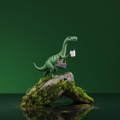 a toy dinosaur holding a cup on top of a rock