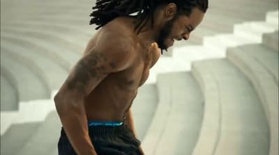 a man with dreadlocks standing in a stadium