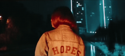a woman with red hair wearing a jacket that says hope
