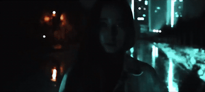 a person standing in the dark with a city in the background