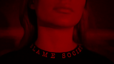 a woman wearing a black shirt with a red light behind her