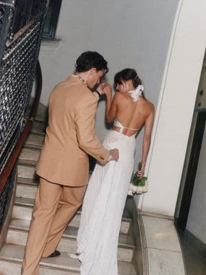 a bride and groom are standing on the stairs