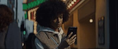 a person standing in front of a building looking at a cell phone