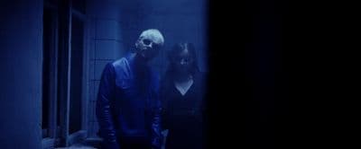 a man and a woman standing in a dark room