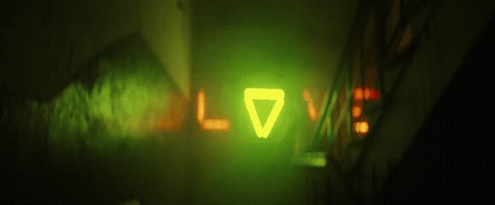 a green light that is on the side of a building