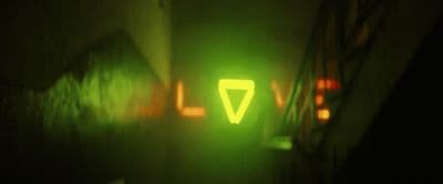 a green light that is on the side of a building