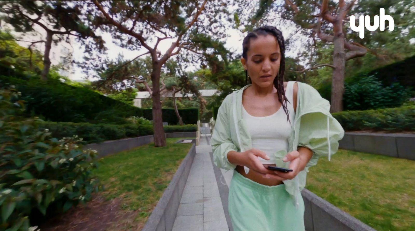 a woman standing on a sidewalk holding a cell phone