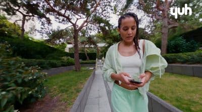 a woman standing on a sidewalk holding a cell phone