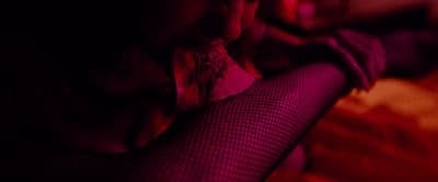 a woman sitting on a bed in a dark room