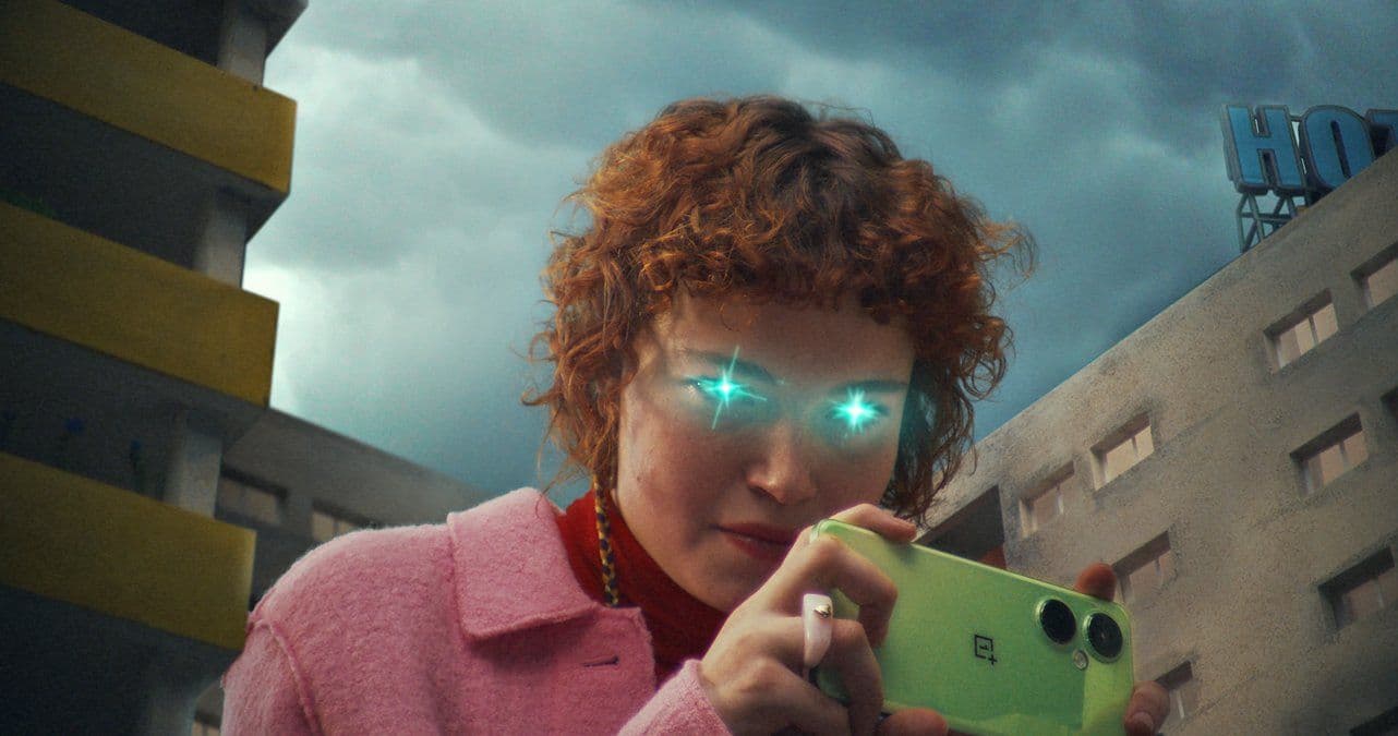 a woman holding a green cell phone in front of a building