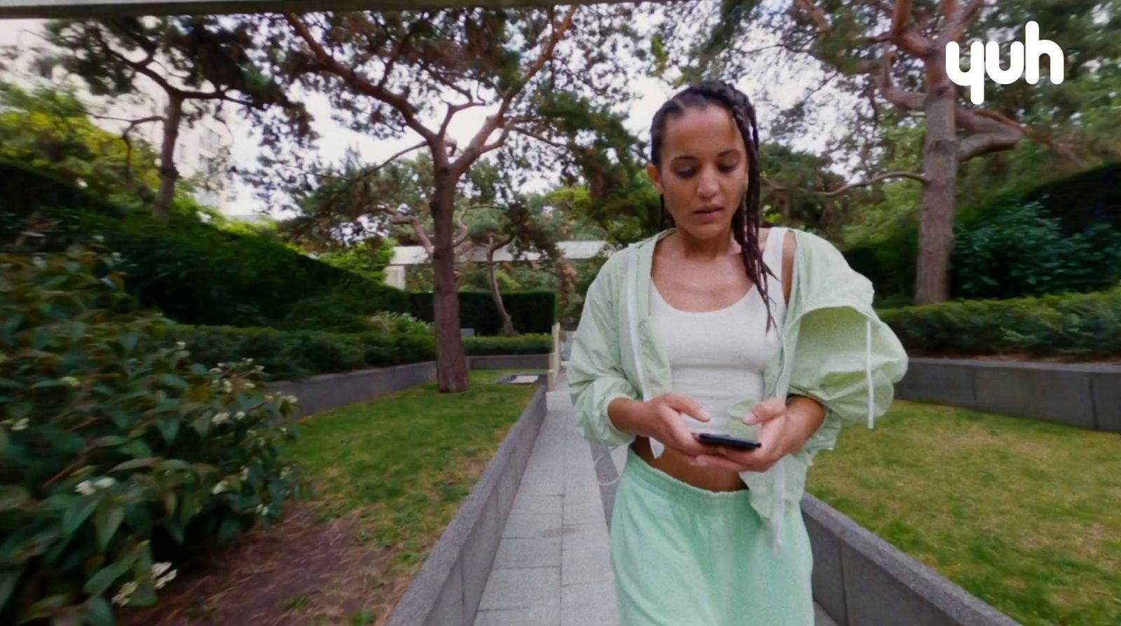 a woman standing on a sidewalk looking at her cell phone