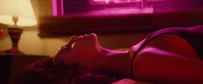 a woman laying on a bed in front of a window