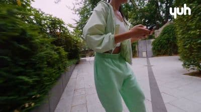 a woman standing on a sidewalk holding a cell phone