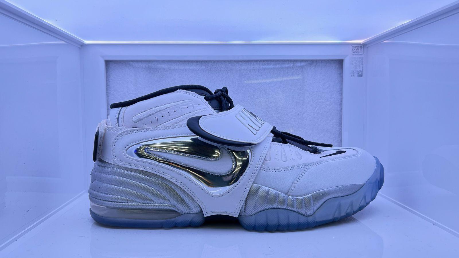 a pair of white and blue sneakers in a display case