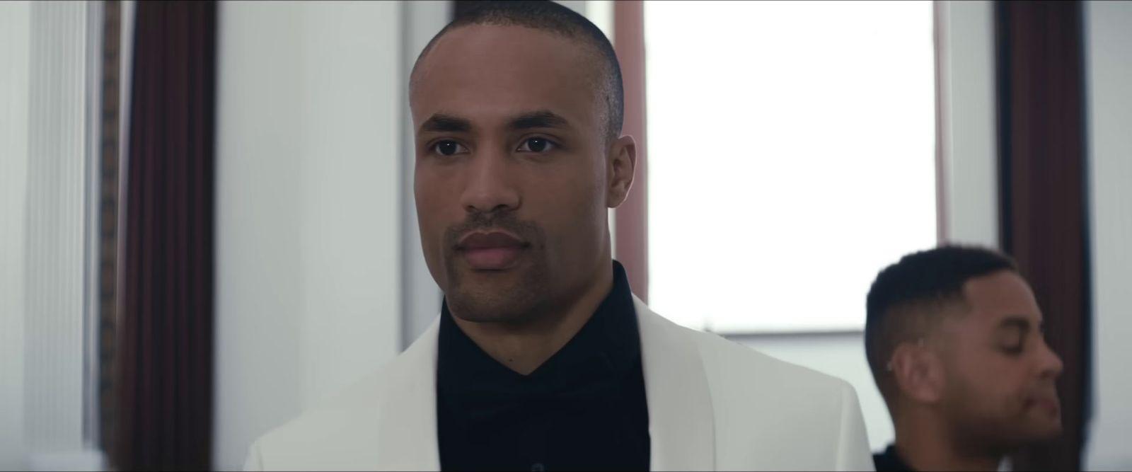 a man in a white suit and a man in a black shirt