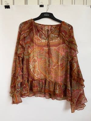 a blouse hanging on a hanger on a wall
