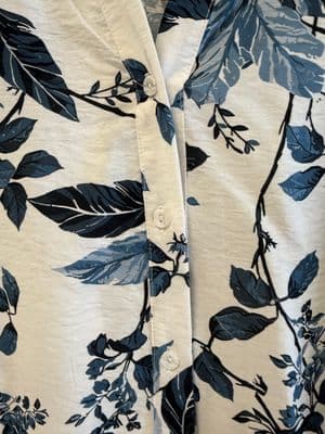 a close up of a shirt with leaves on it