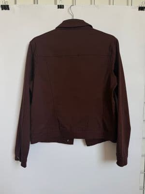 a brown jacket hanging on a white wall