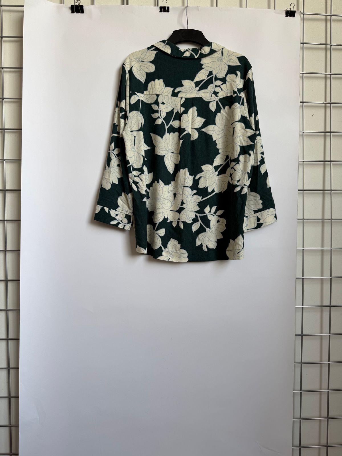 a floral shirt hanging on a white wall