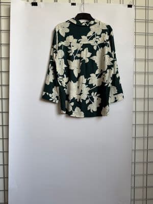 a floral shirt hanging on a white wall