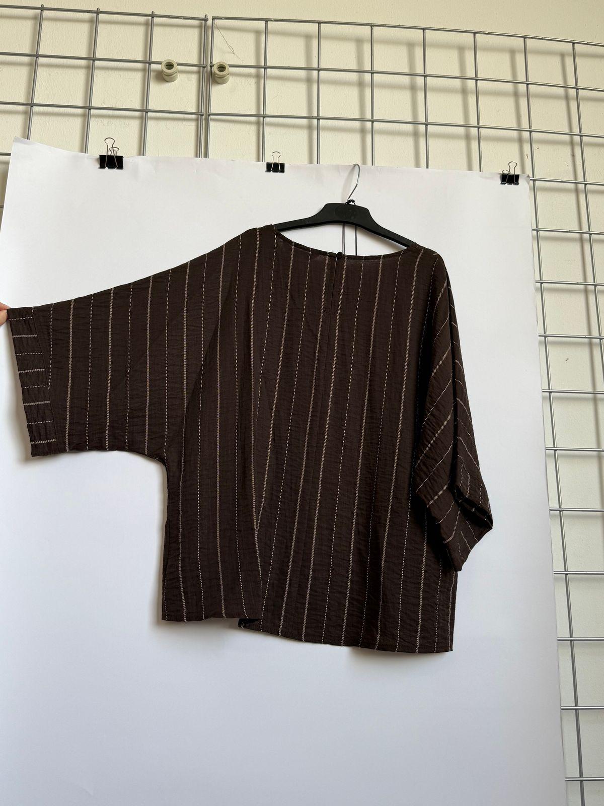 a person holding a piece of clothing on a hanger