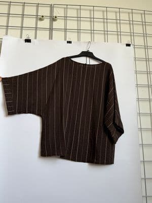 a person holding a piece of clothing on a hanger