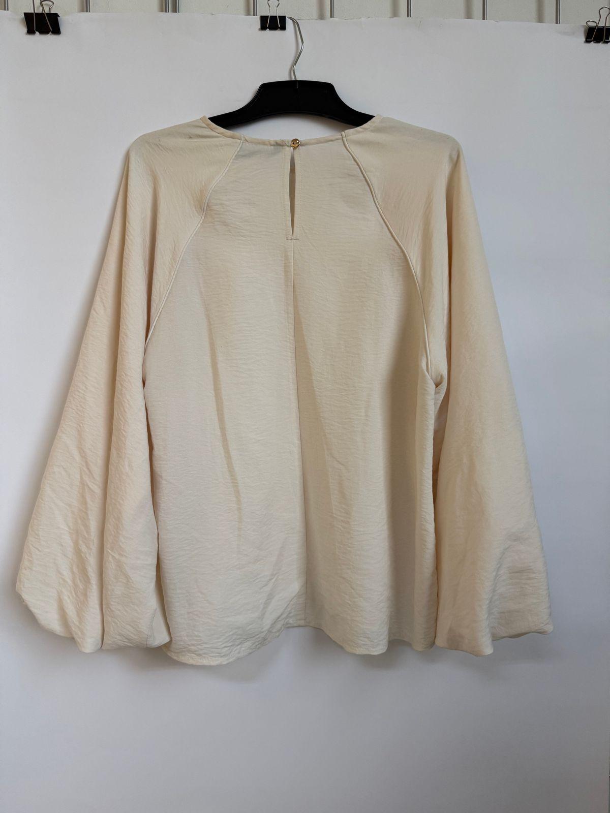 a white shirt hanging on a white wall