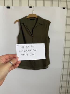 a person holding a piece of paper in front of a picture of a shirt
