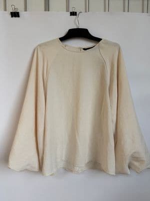 a white shirt hanging up against a wall
