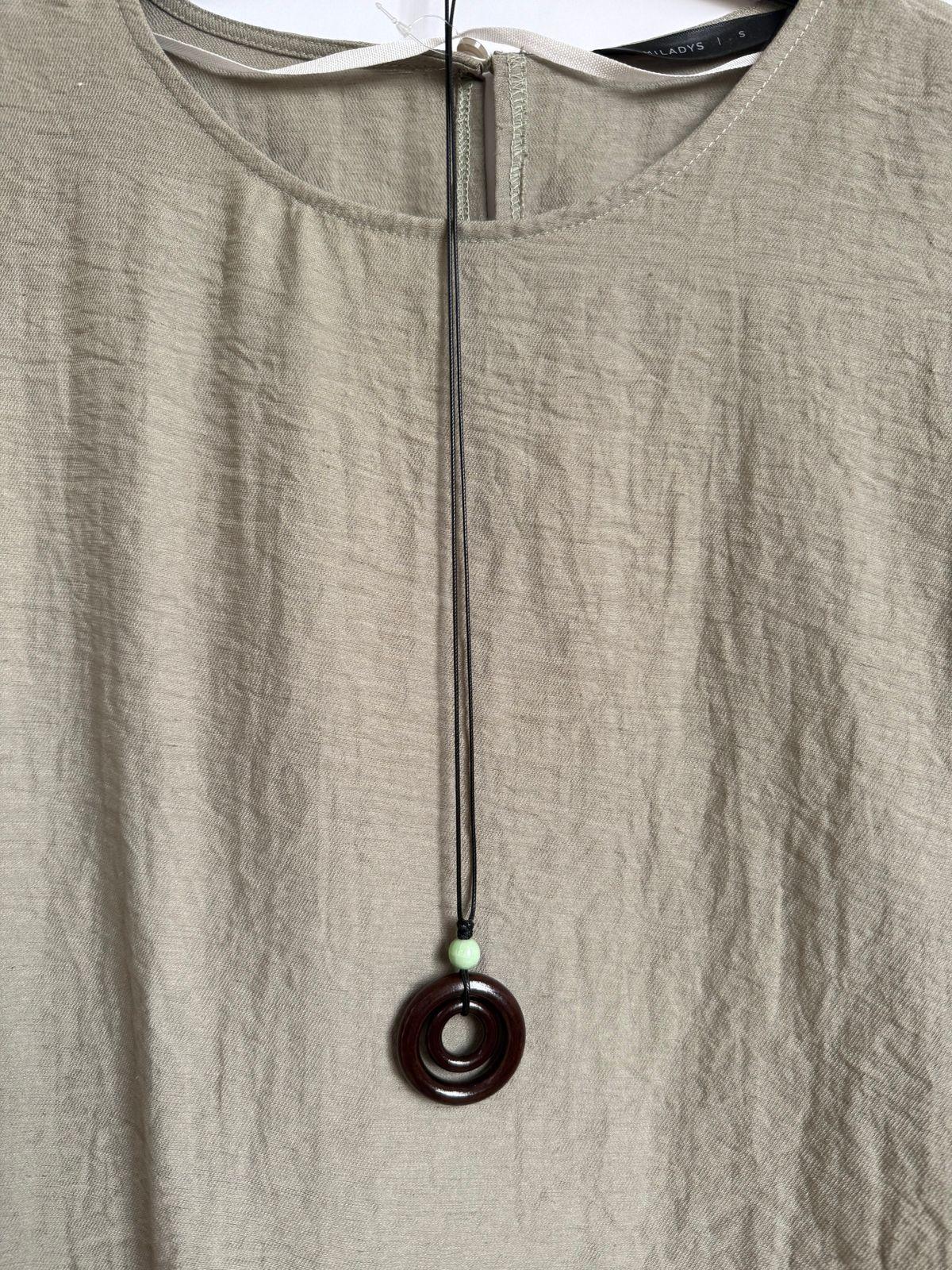 a white shirt with a brown necklace hanging from it