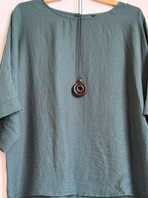 a green shirt with a necklace hanging from it