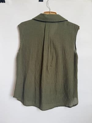 a green vest hanging on a white wall