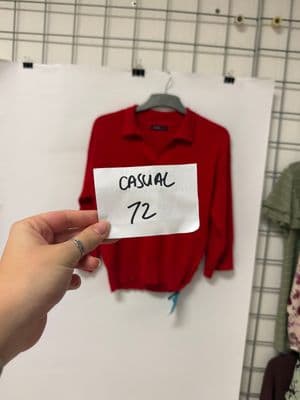 a person holding a piece of paper in front of a display of clothing