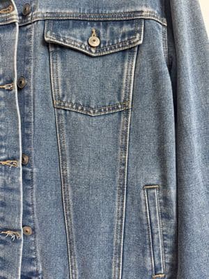 a blue jean jacket is hanging on a hanger
