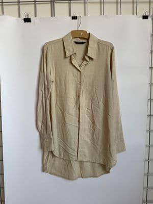 a tan shirt hanging on a white wall