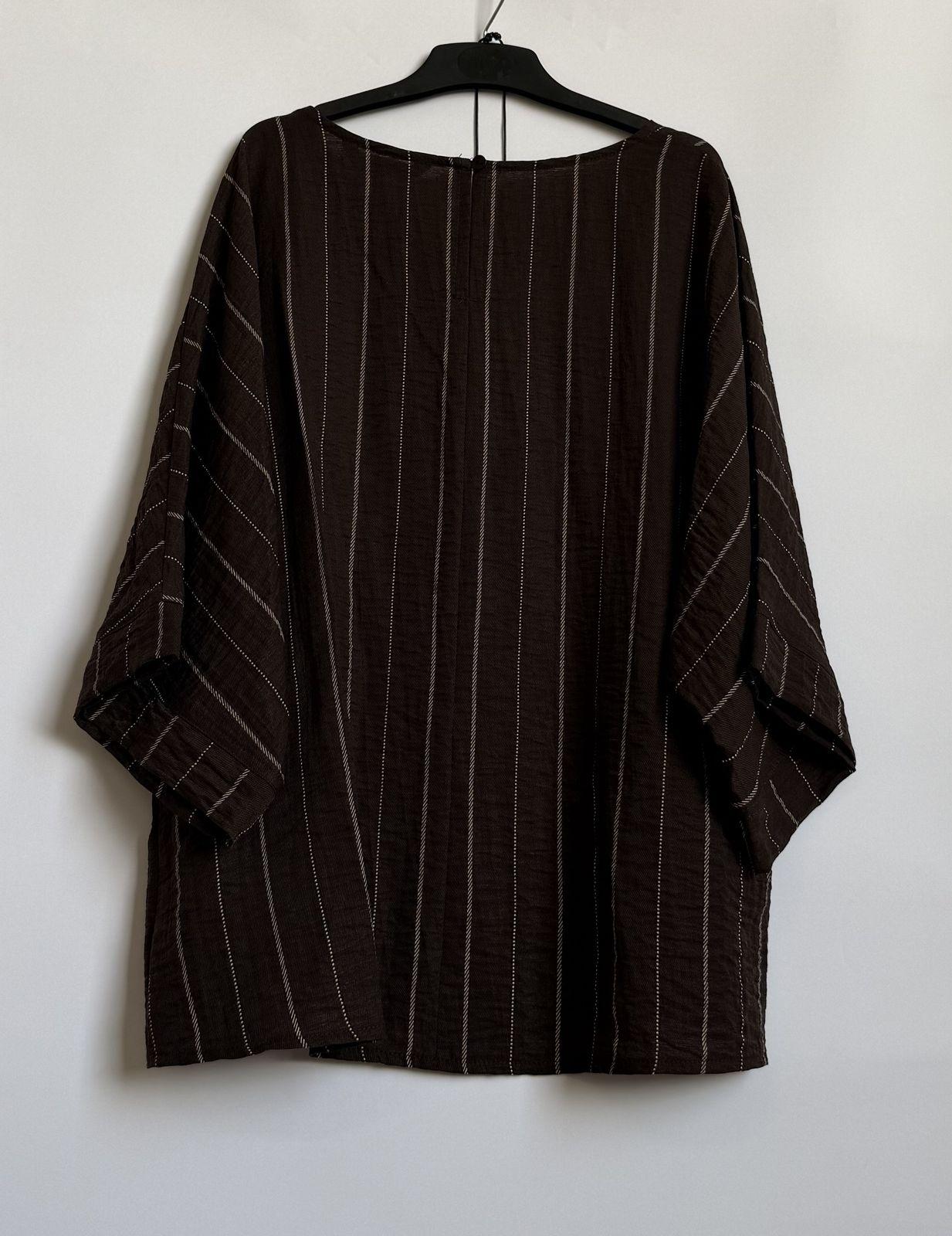 a black and white striped shirt hanging on a wall