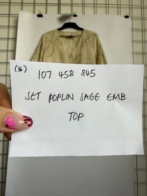 a hand holding a piece of paper with writing on it