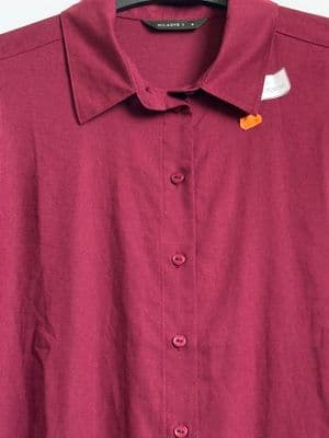 a red shirt is hanging on a hanger