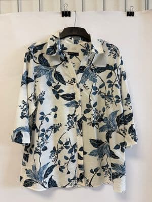 a blue and white shirt hanging on a clothes rack