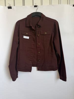 a brown jacket hanging on a white wall