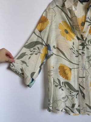 a person holding onto a shirt with yellow flowers on it