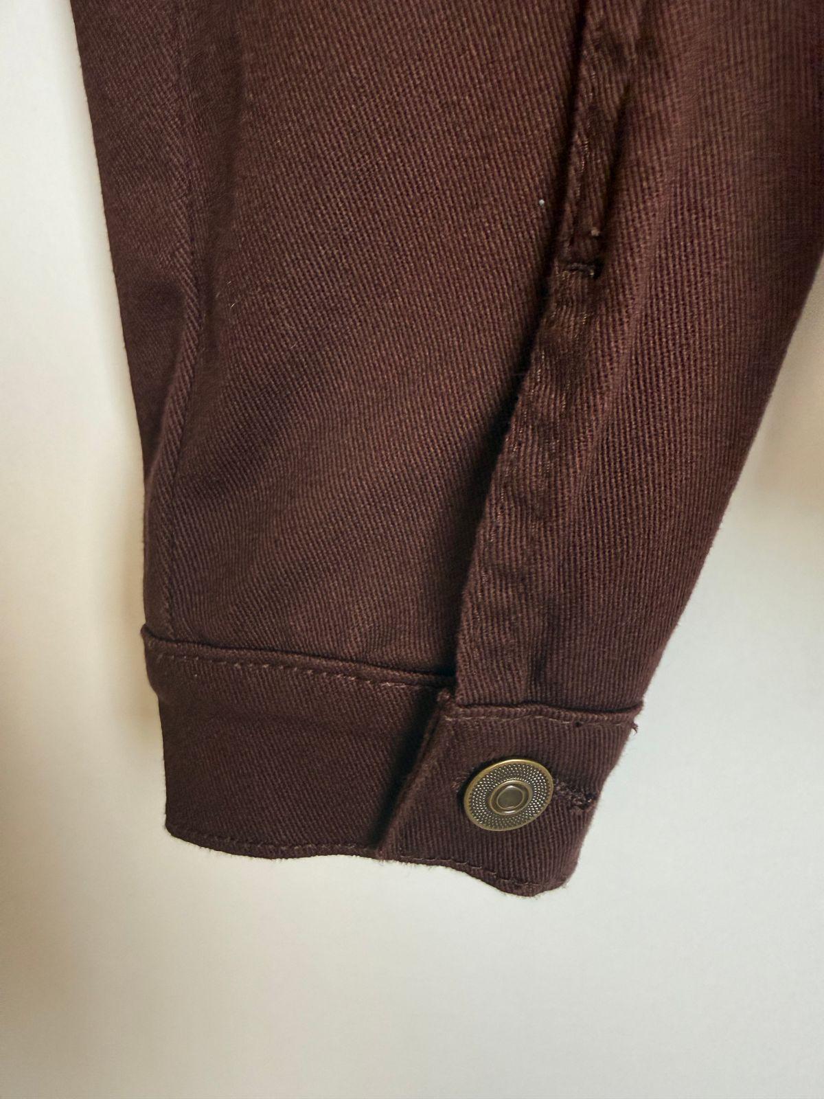 a close up of a brown shirt on a white surface