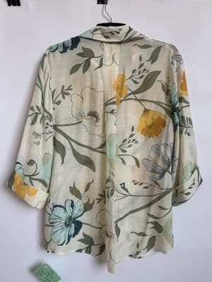 a white shirt with yellow and blue flowers on it