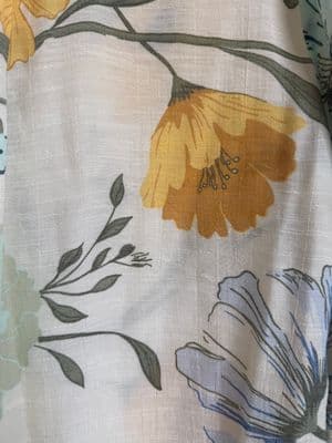 a close up of a flowered fabric with yellow and blue flowers